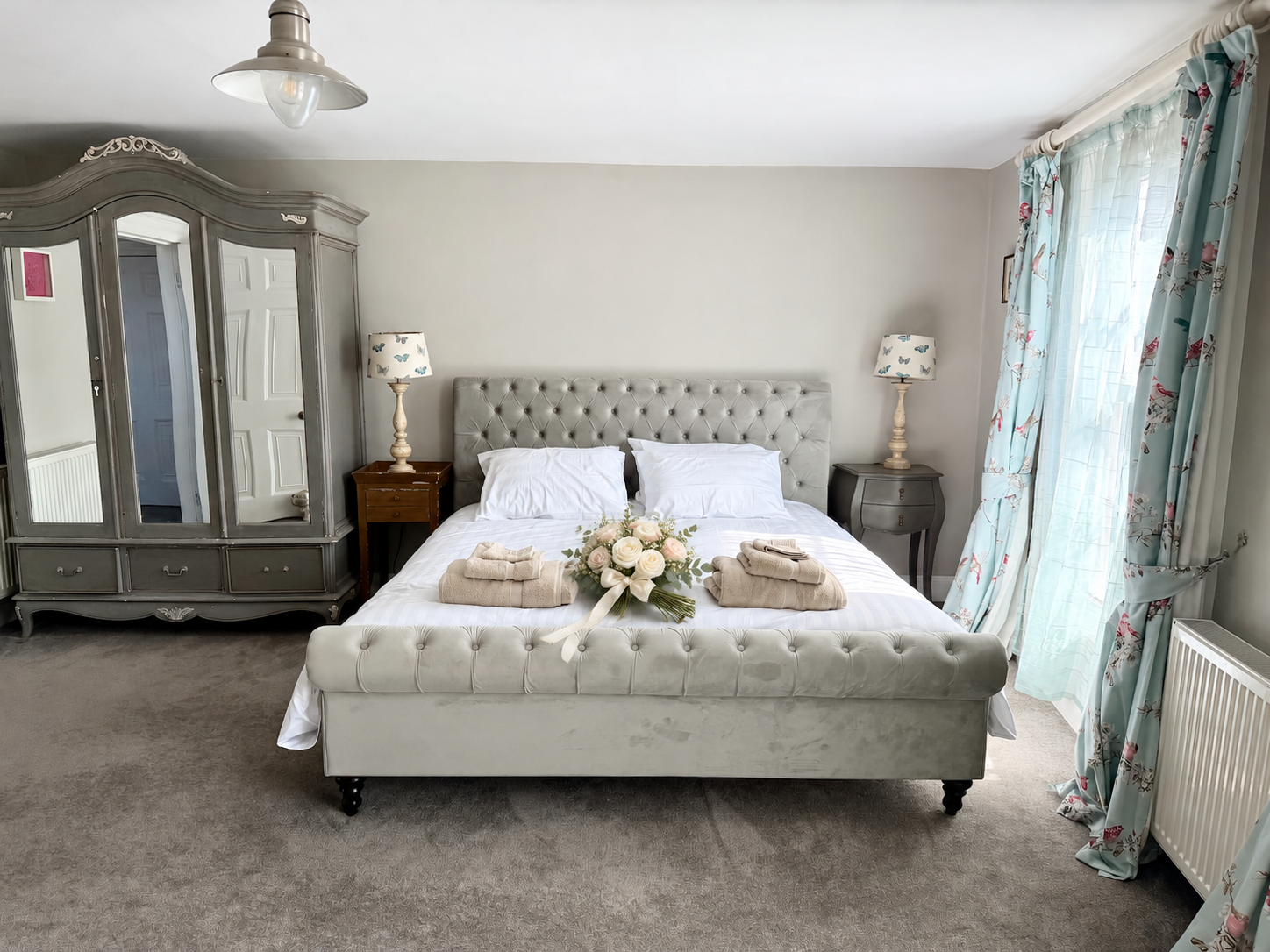 Bridal suite with blue floral curtains and a bouquet styled on the bed