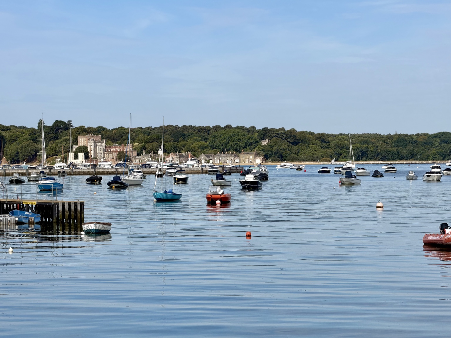 Boats on the water with Brownsea Island and its castle in the background in daylight