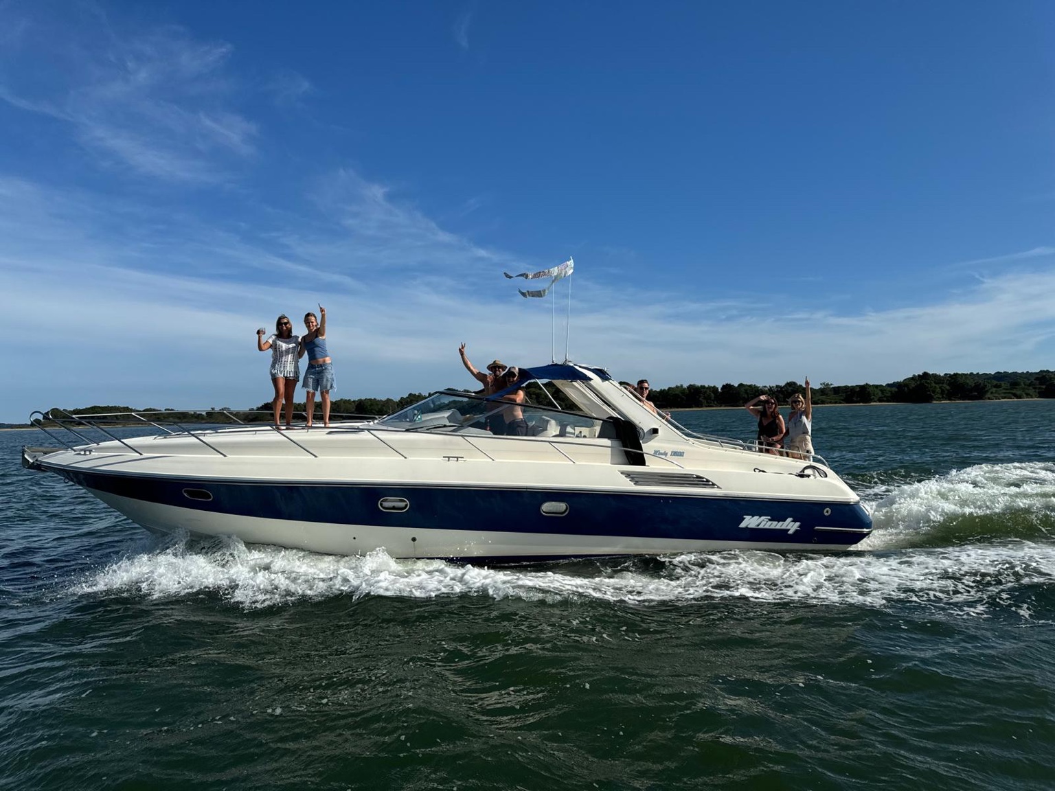 Motorboat cruising through Poole Harbour on a sunny day