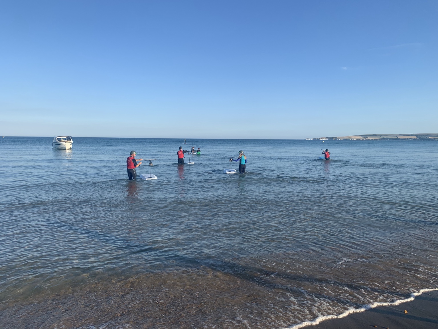 A group learning to efoil in calm shallow water