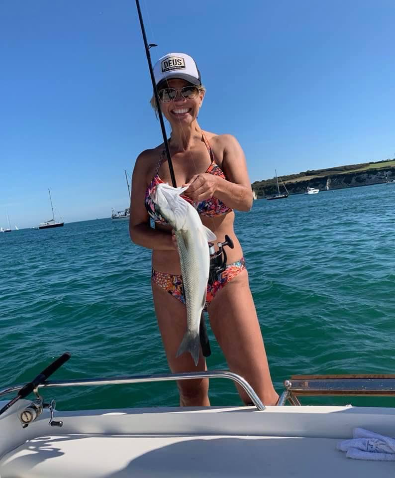 A freshly caught fish aboard a boat on a sunny day