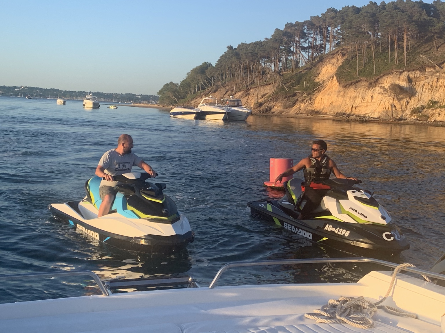 Two jet skis beside the sunlit coastline